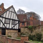 In 1933, Lincoln's Crooked House was marked for demolition; work revealed a hidden timber-framed building behind its brick façade and saved it; today it is one of the Cathedral Quarter's most photographed buildings
